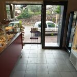 Vue de l'intérieure d'une boulangerie, donnant sur la porte de sortie.