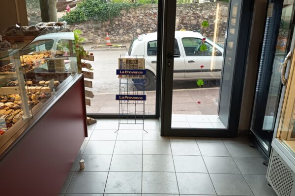 Vue de l'intérieure d'une boulangerie, donnant sur la porte de sortie.